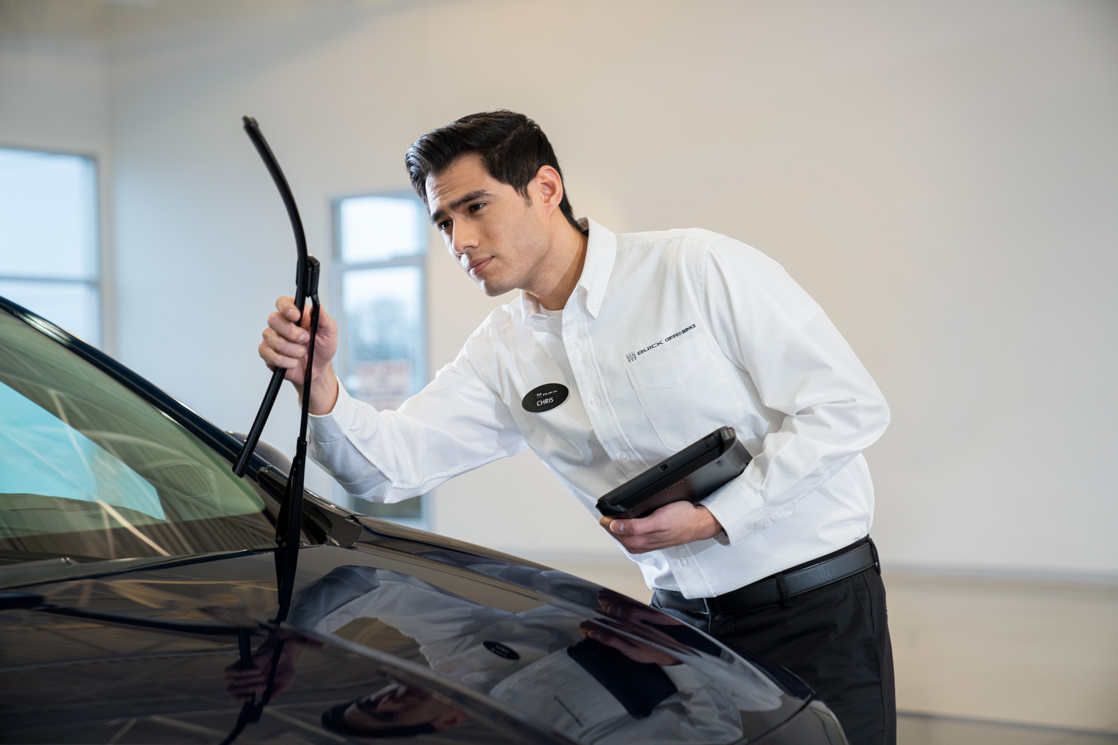 Buick service technician inspecting windshield wipers.