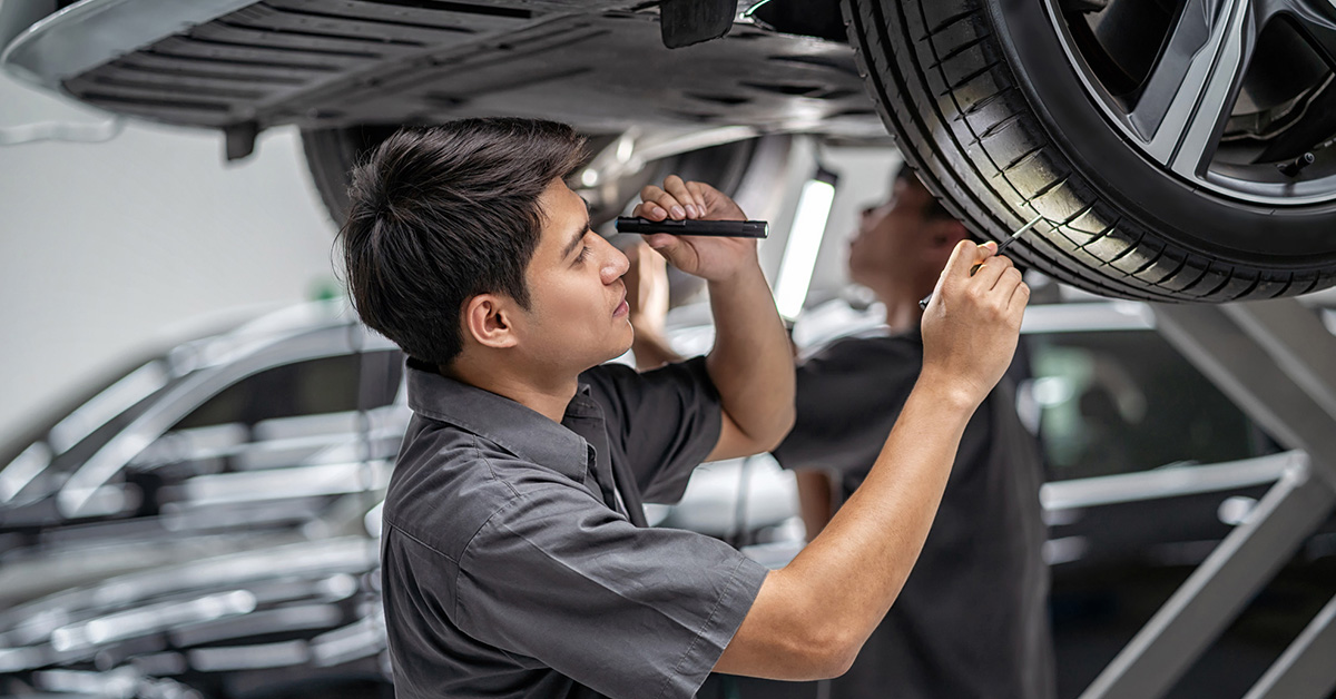 GMC service technician inspecting tread depth
