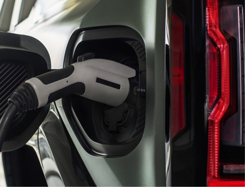 Close up of charging port with charger plugged in on a GMC Hummer EV SUV - Moran Buick GMC Sterling Heights in STERLING HEIGHTS MI