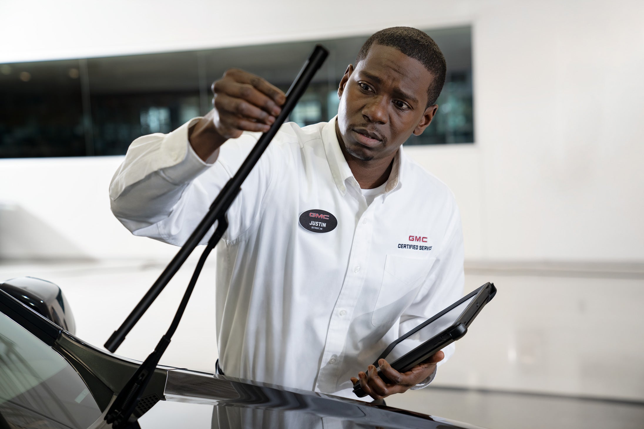 GMC service tech inspecting windshield wipers